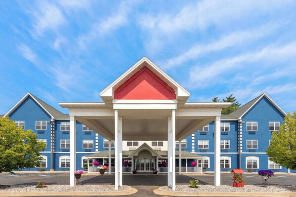 A large, two-story hotel with a red and white entrance canopy, multiple windows, and a blue exterior.