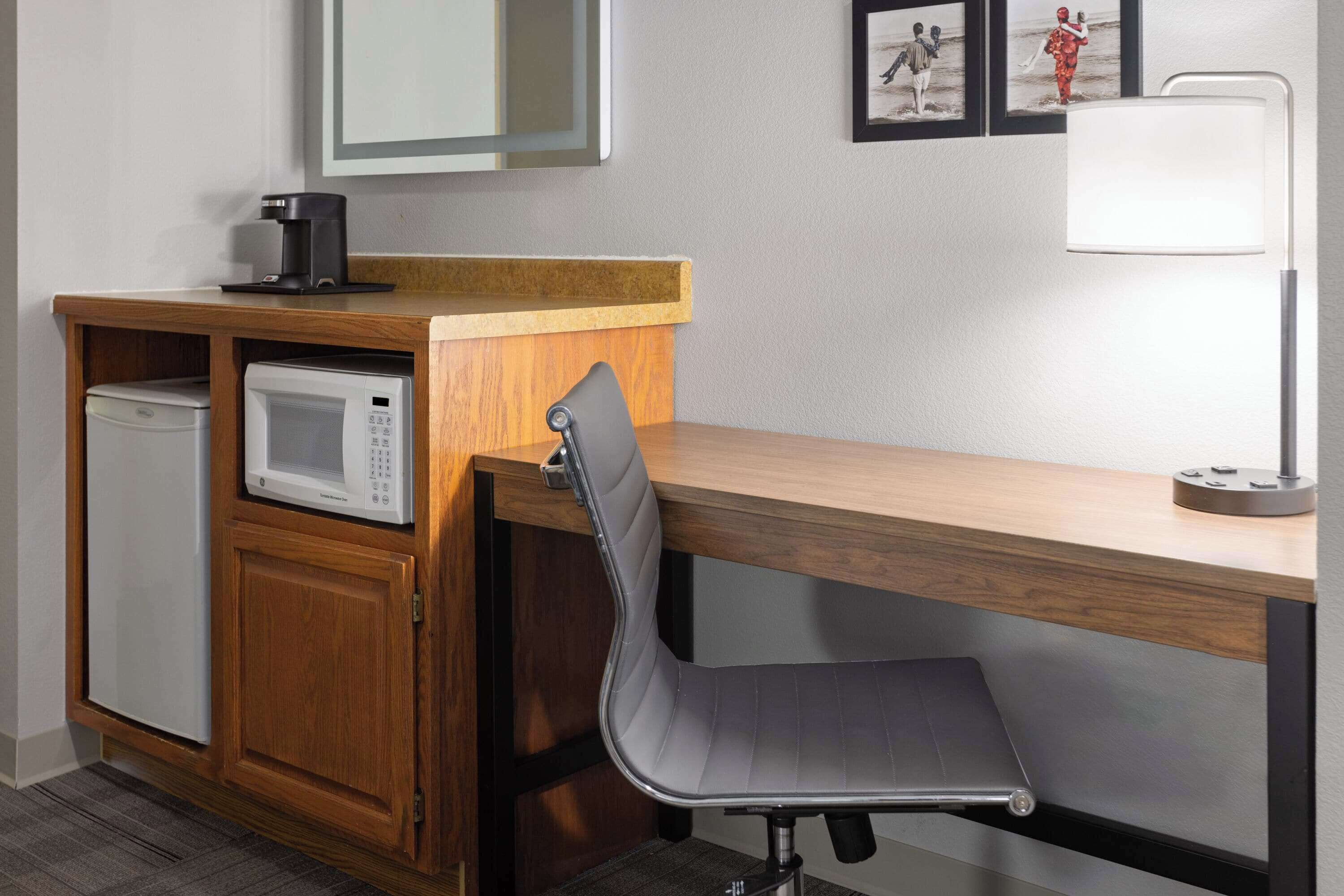 A compact kitchenette with a microwave, coffee maker, and a small refrigerator.