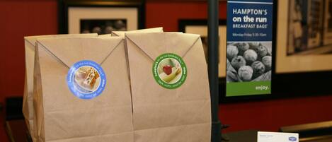 A display of Hampton's on the run breakfast bags with a sign in the background.