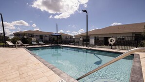 A swimming pool with a 3 ft no diving sign, lounge chairs, and a fence. - Hampton Inn Dade City - Zephyrhills (Dade City)