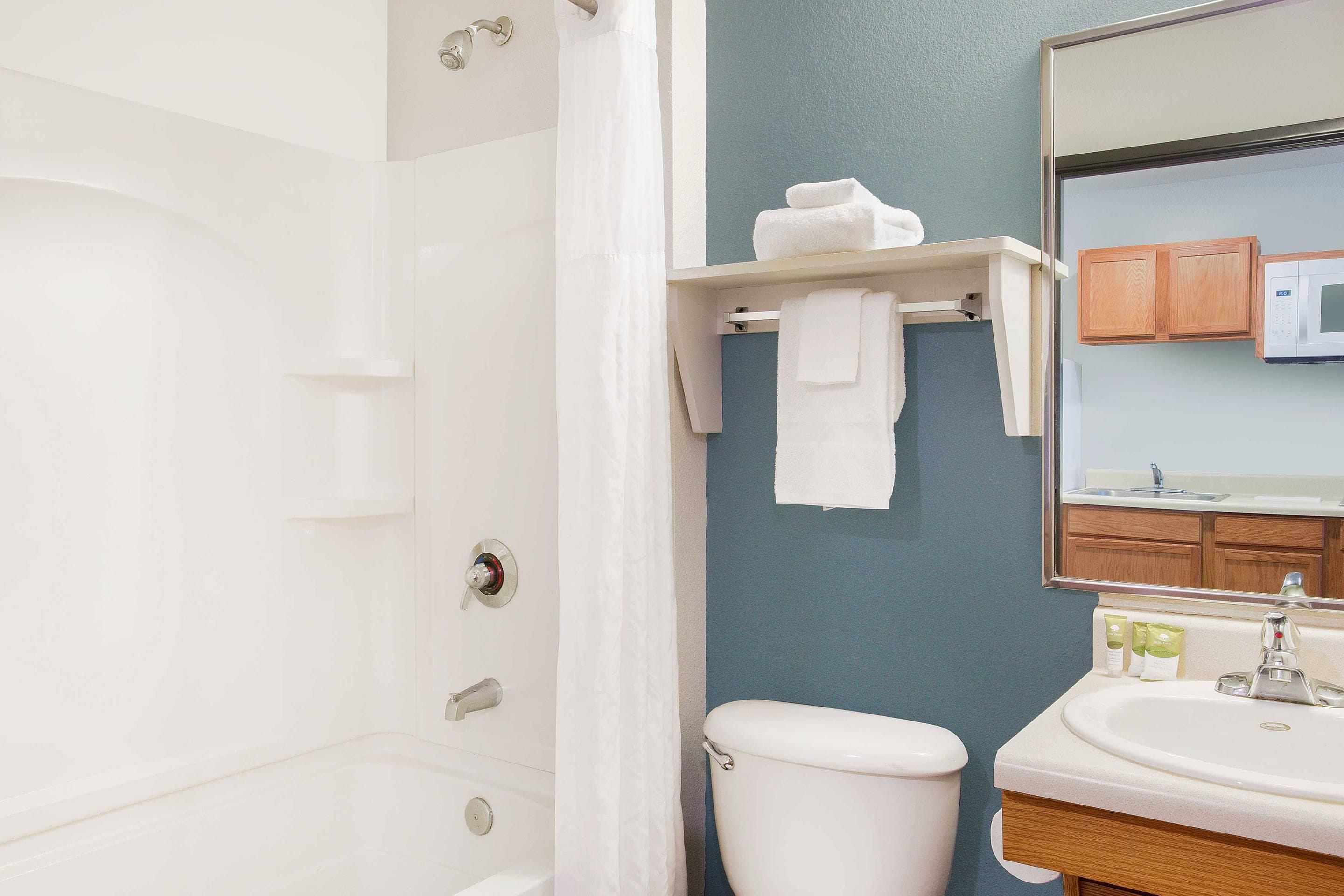 Un baño con bañera, inodoro, lavabo y toallero.