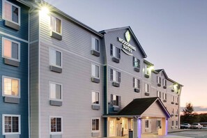 A multi-story hotel with a prominent sign for 'Woodspring Suites.' - WoodSpring Suites Charlotte Shelby (Shelby)