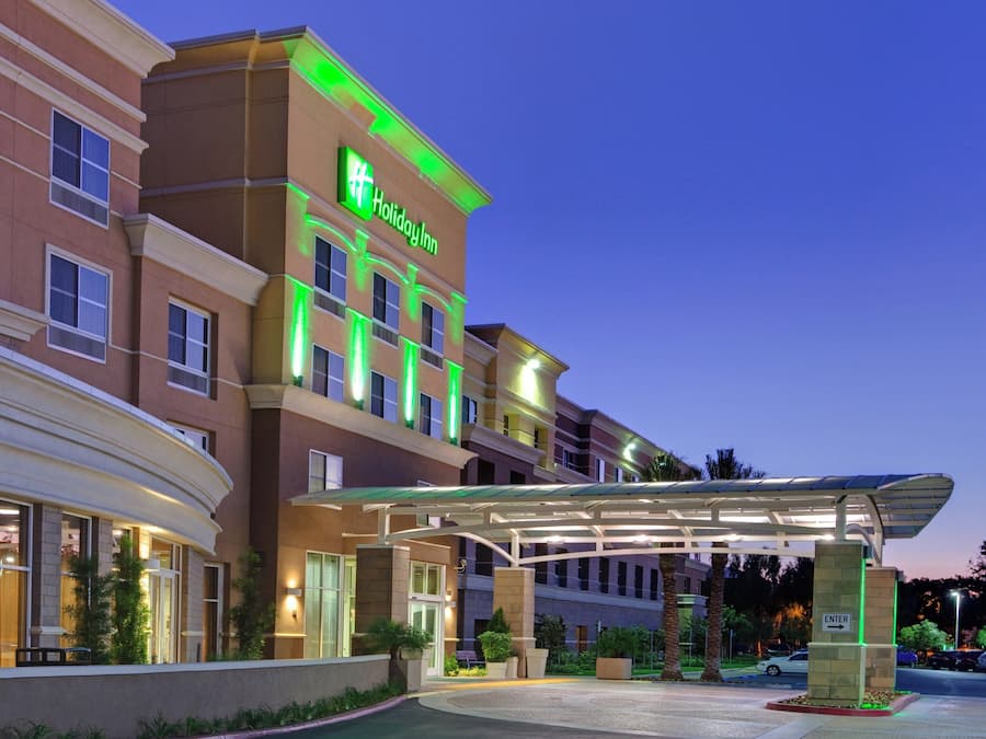 A Holiday Inn hotel with a covered entrance, multiple floors, and a well-lit facade.