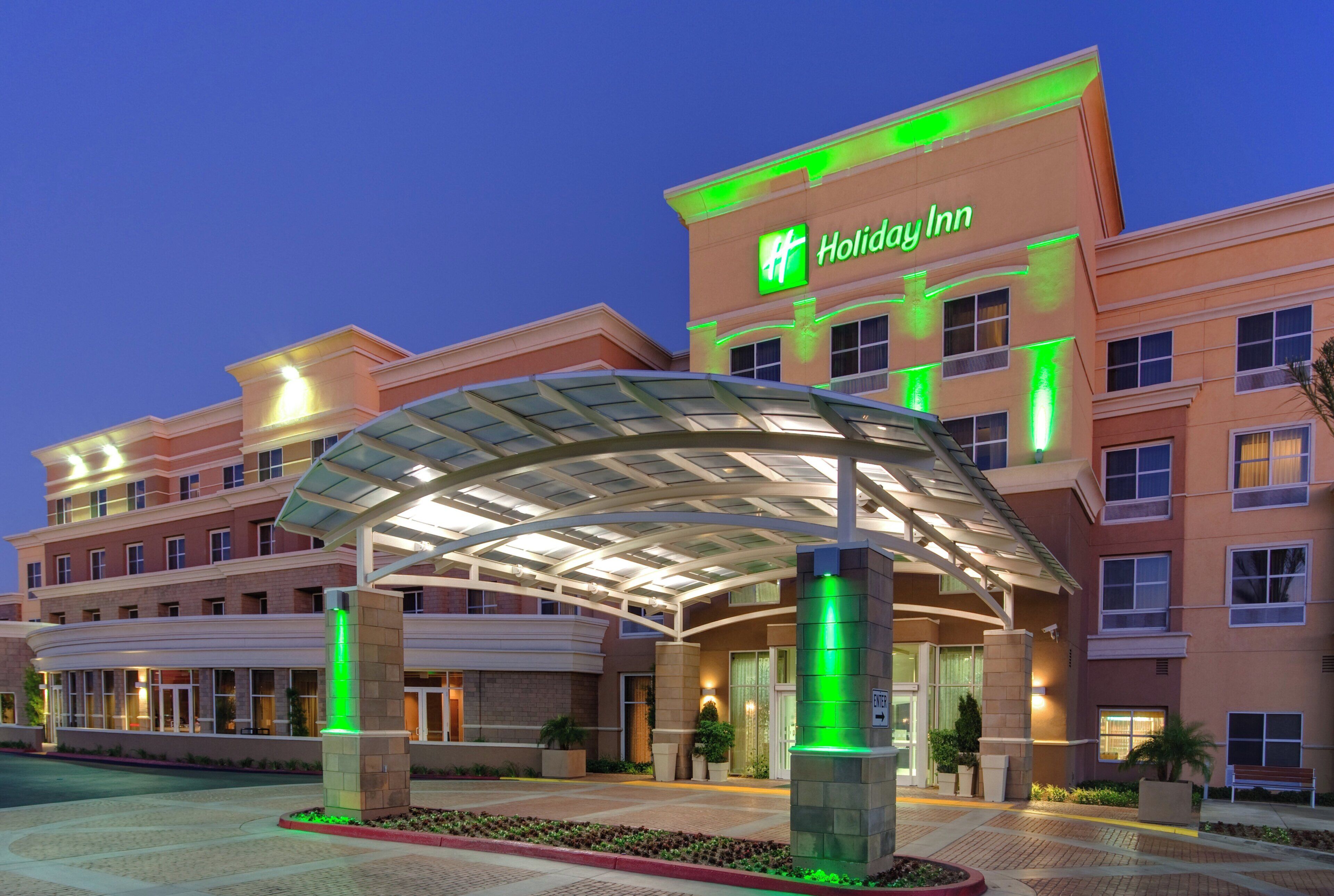 A Holiday Inn hotel with a covered entrance and a landscaped area in front.