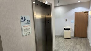 An elevator with a sign indicating emergency evacuation plan and a door with a sign for elevator equipment.