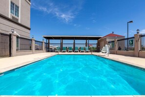 Una piscina al aire libre de temporada, sillones reclinables de piscina