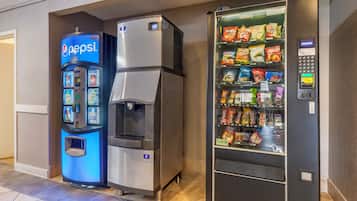 Een automaat met een Pepsi logo, een waterdispenser en een snackautomaat met diverse merken.