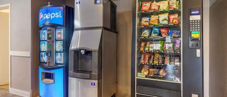 Máquina expendedora con logotipo de Pepsi, dispensador de agua y máquina expendedora de snacks de varias marcas.