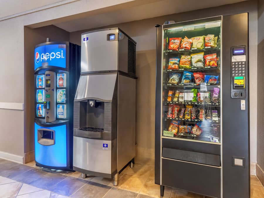Ein Getränkeautomat mit Pepsi-Logo, ein Wasserspender und ein Snackautomat mit verschiedenen Marken.