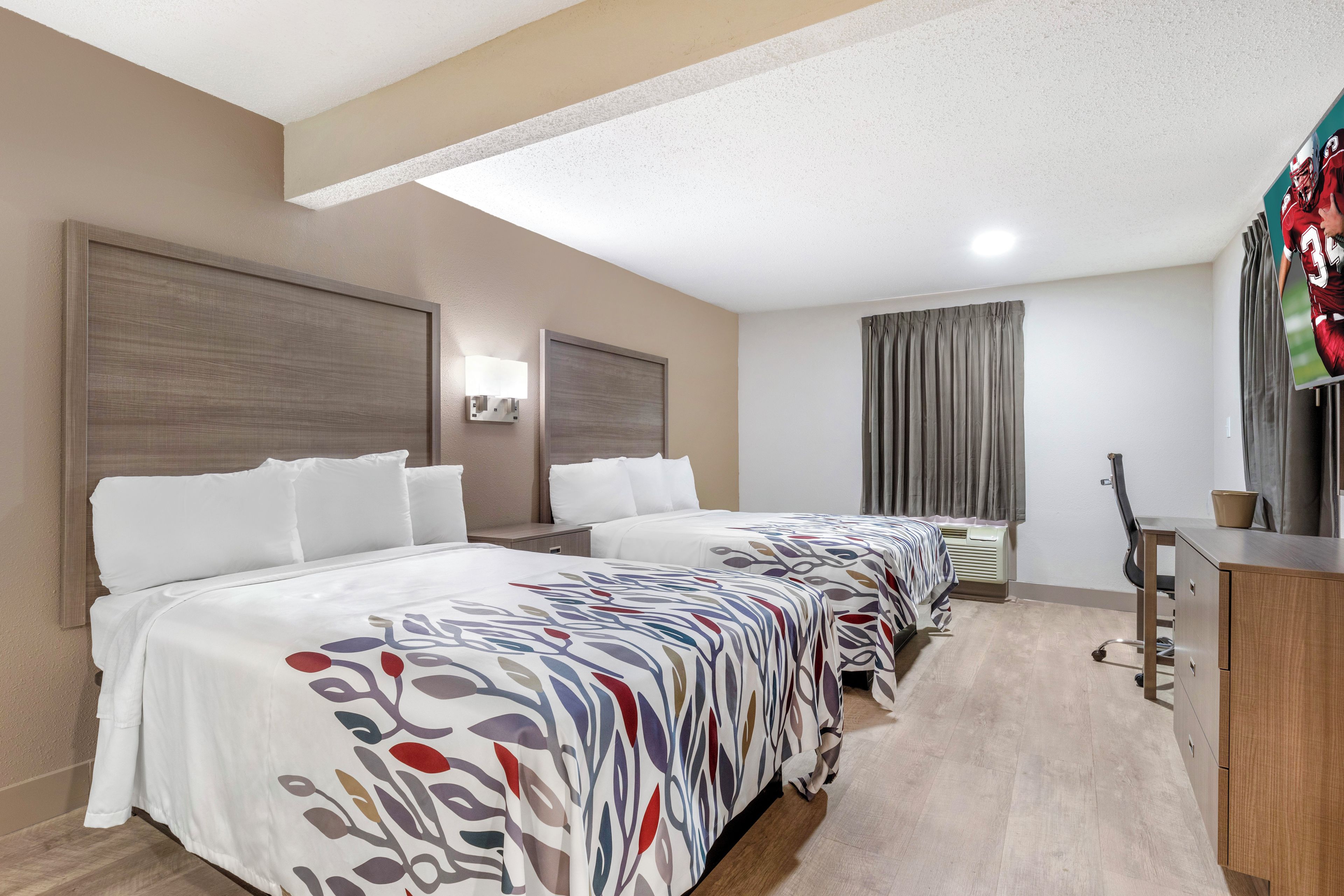 Una habitación de hotel con una cama grande, un escritorio y una silla.