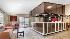 Un hall d'entrée de Red Roof Inn avec un comptoir d'accueil, un espace salon et une vue sur l'extérieur.