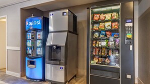 Un distributeur automatique de boissons proposant des produits Pepsi et un présentoir réfrigéré contenant des en-cas.