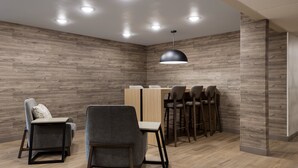 A modern dining area with wooden walls, recessed ceiling lights, and a central table with chairs.
