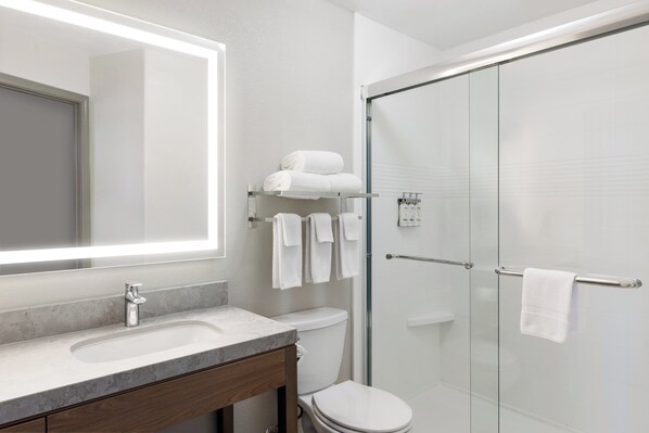 A modern bathroom with a marble sink, a glass shower enclosure, and a toilet. - (Yuma)