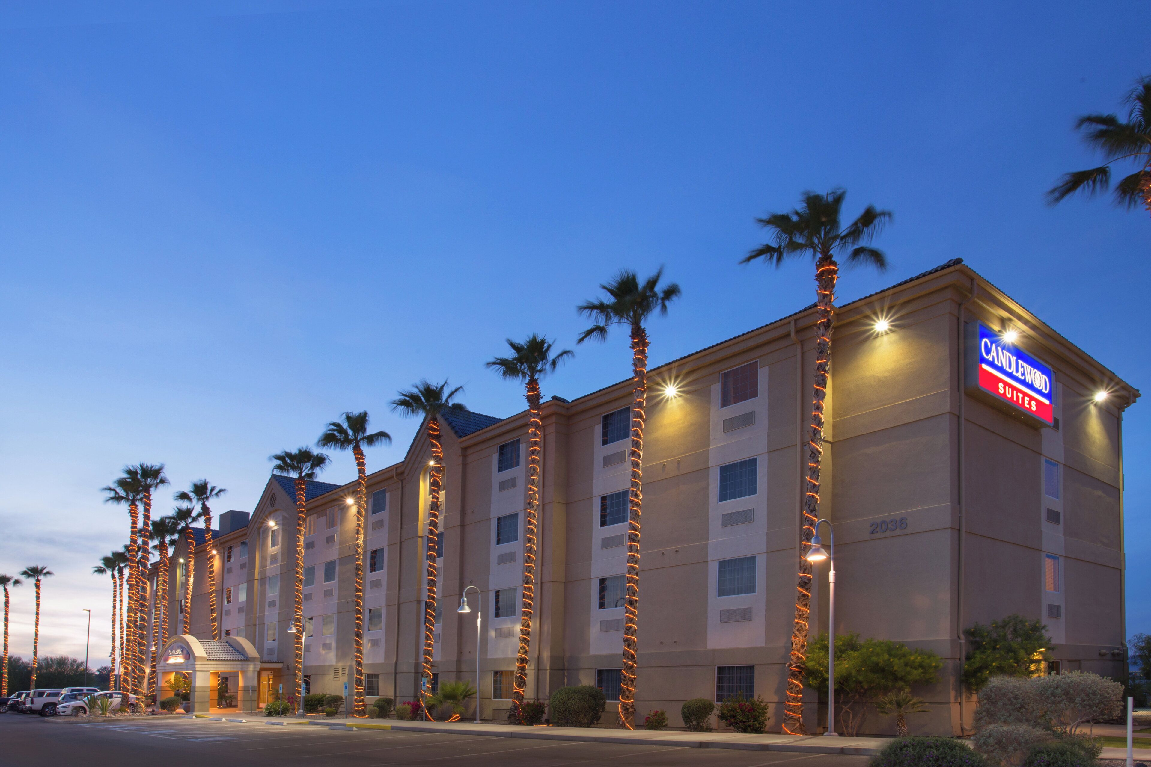 A hotel with multiple floors, palm trees, and a prominent sign for Candlewood Suites.