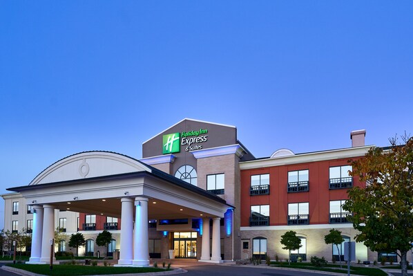 Un hotel Holiday Inn Express & Suites con ingresso coperto, diversi piani e cielo sereno.
