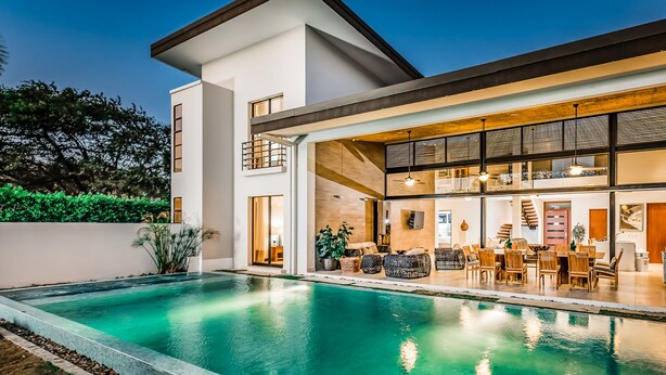 A modern house with a swimming pool, large windows, and a dining area. - Reserva Conchal Beach Resort, Golf & Spa (Cabo Velas)