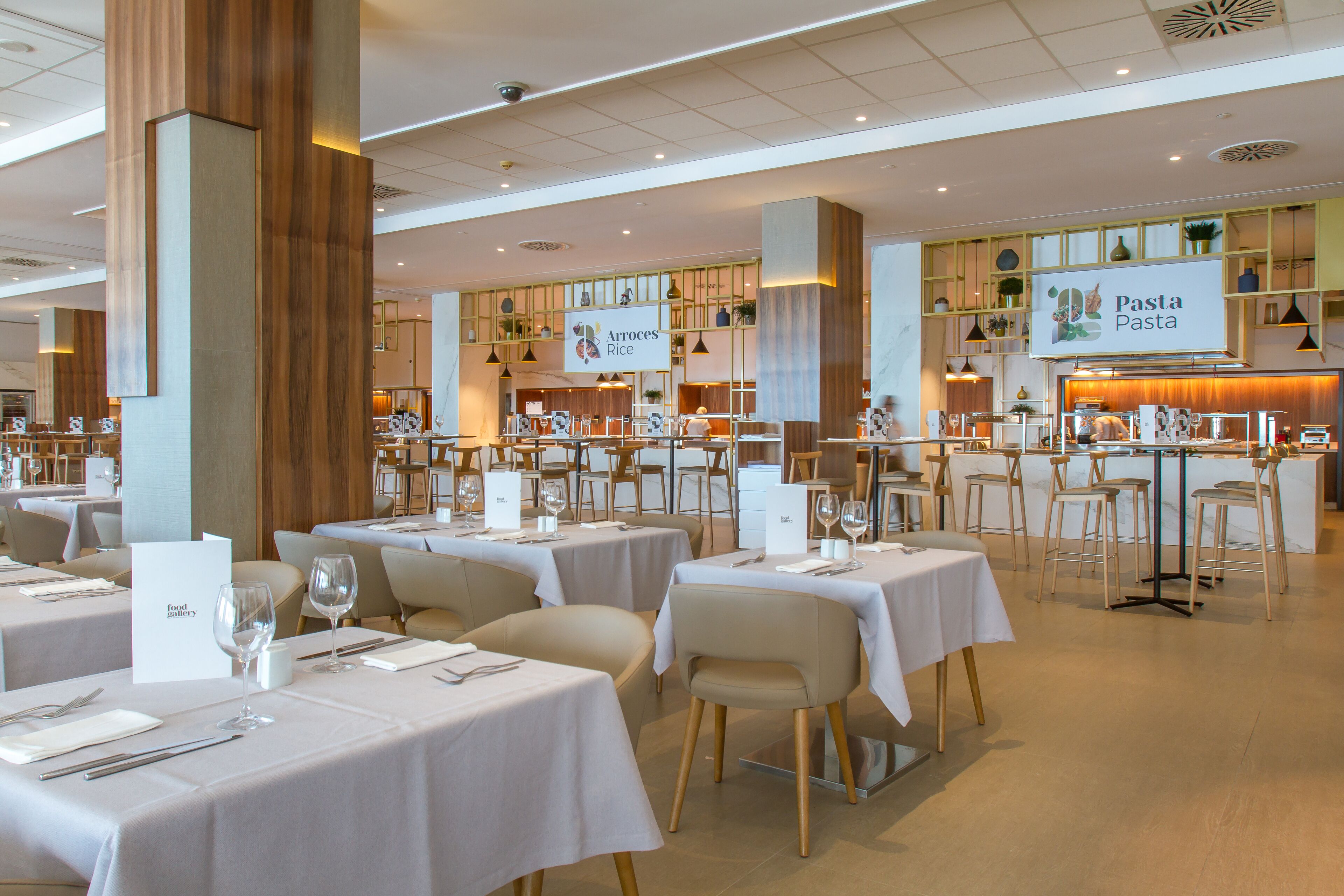 Een restaurant met meerdere tafels, stoelen en een toonbank, met een bord waarop staat 