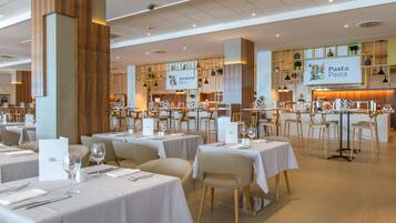 Een restaurant met meerdere tafels, stoelen en een toonbank, met een bord waarop staat
