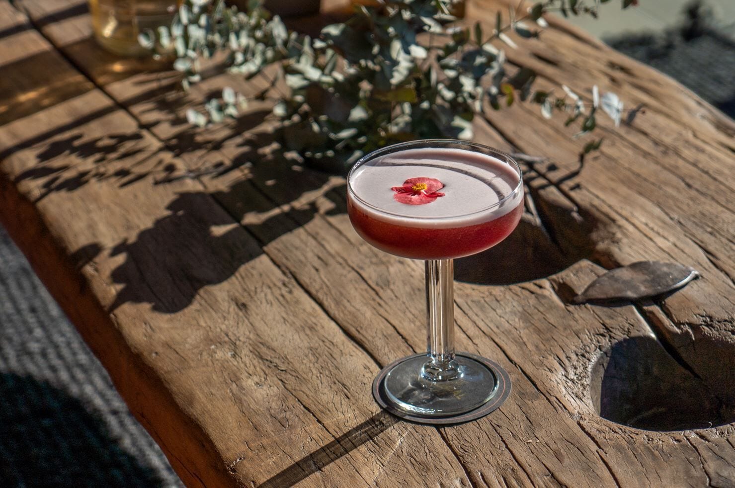 A cocktail in a glass on a wooden table.