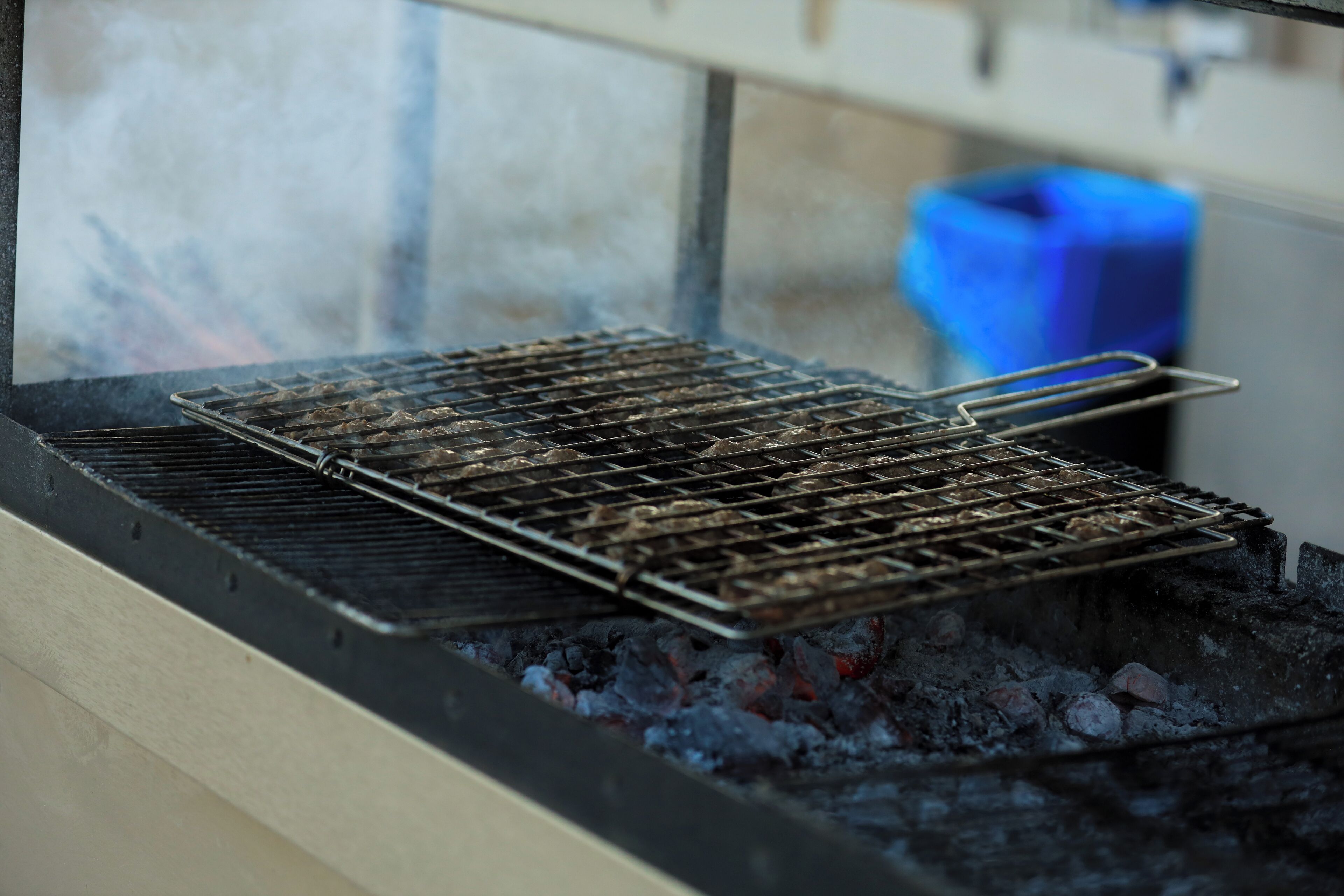 Una parrilla con una rejilla metálica sobre carbón encendido.