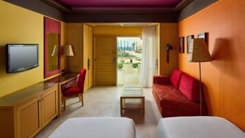 A hotel room with a bed, a desk, a chair, a sofa, and a TV.