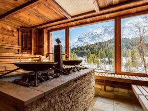 A wooden cabin with a stone counter, two large bowls, and a view of snow-covered mountains. - Schloss Elmau Luxury Spa Retreat & Cultural Hideaway (Kruen)