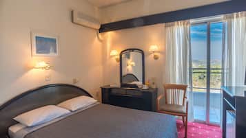 Habitación de hotel con cama, lámparas de noche, cómoda, espejo, silla y balcón con vistas.
