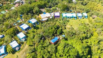 An aerial view of a resort with multiple buildings surrounded by dense greenery.
