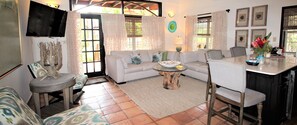 A cozy living area with a sofa, a coffee table, and a TV mounted on the wall.