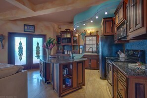 A kitchen with wooden cabinets, a granite countertop, and a built-in oven.
