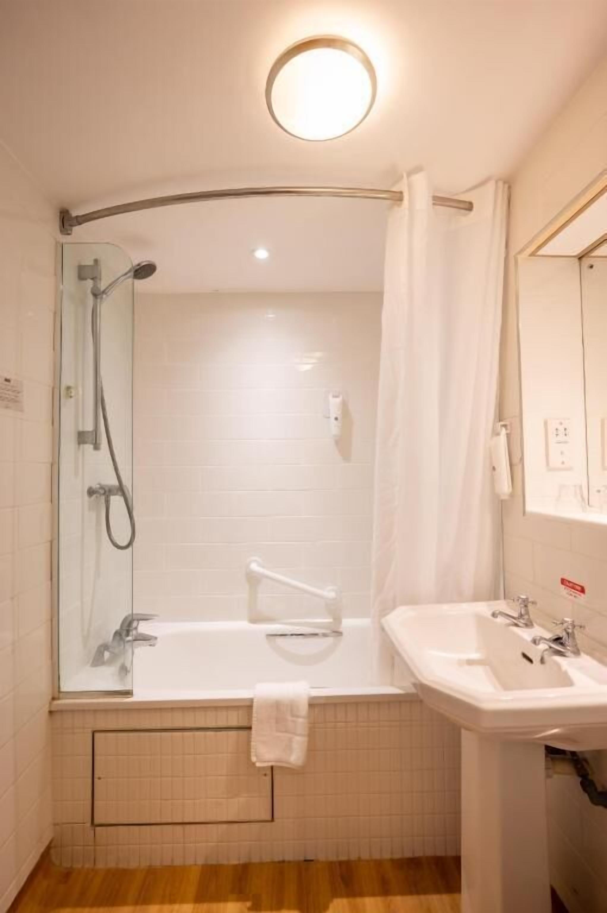 Une salle de bain avec une douche à parois de verre, une baignoire et un lavabo.