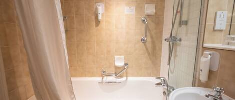 A bathroom with a bathtub, a shower, a sink, and a glass shower enclosure.