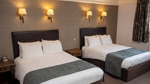 A hotel room with two beds, each with a headboard, bedside tables, and lamps. - Castle And Ball by Greene King Inns (Marlborough)