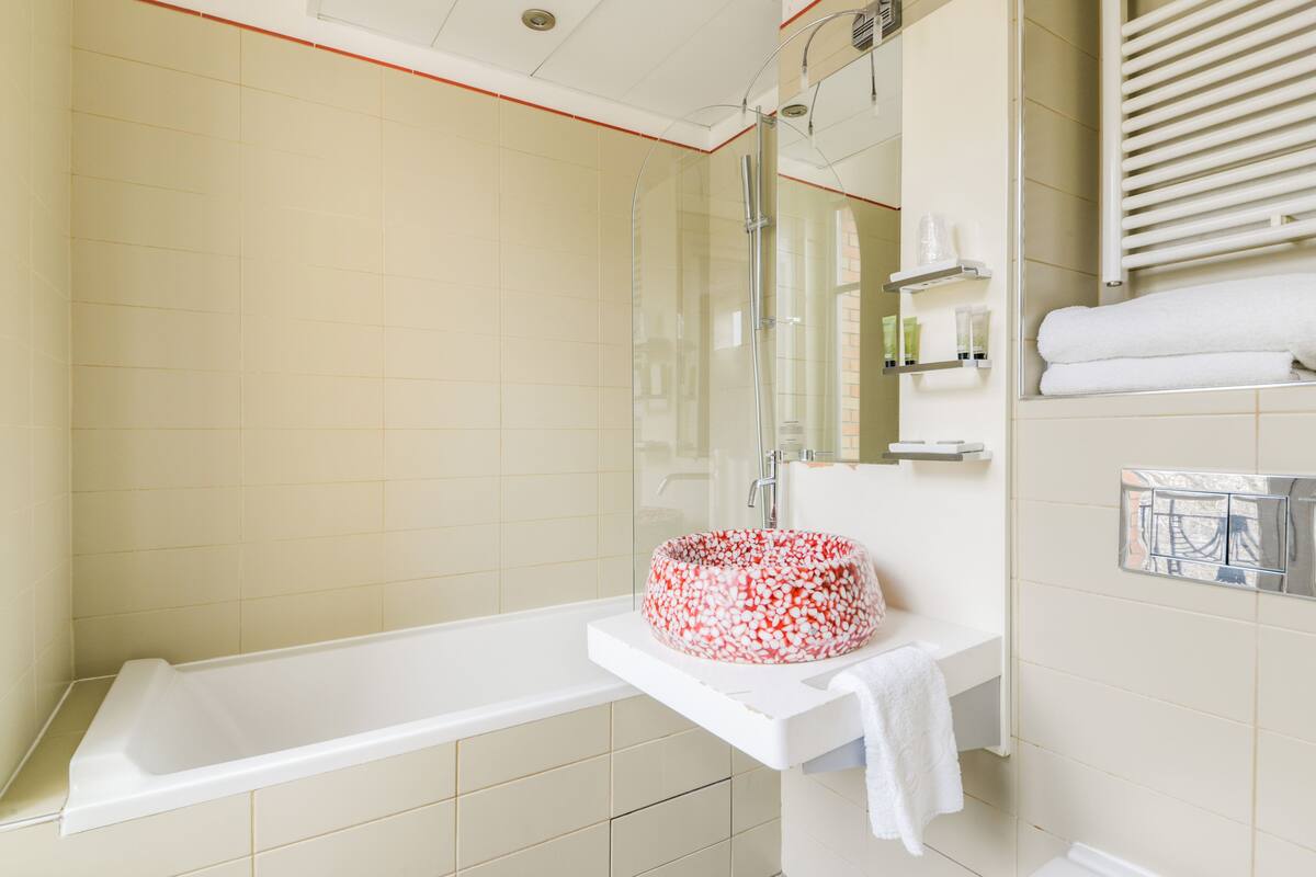 Une salle de bain moderne équipée d’une baignoire, d’une douche et d’un lavabo.