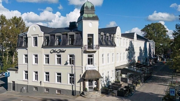 A historic building with a central dome, multiple windows, and a sign indicating it is a hotel. - Moss Hotel & Apartments (Moss)