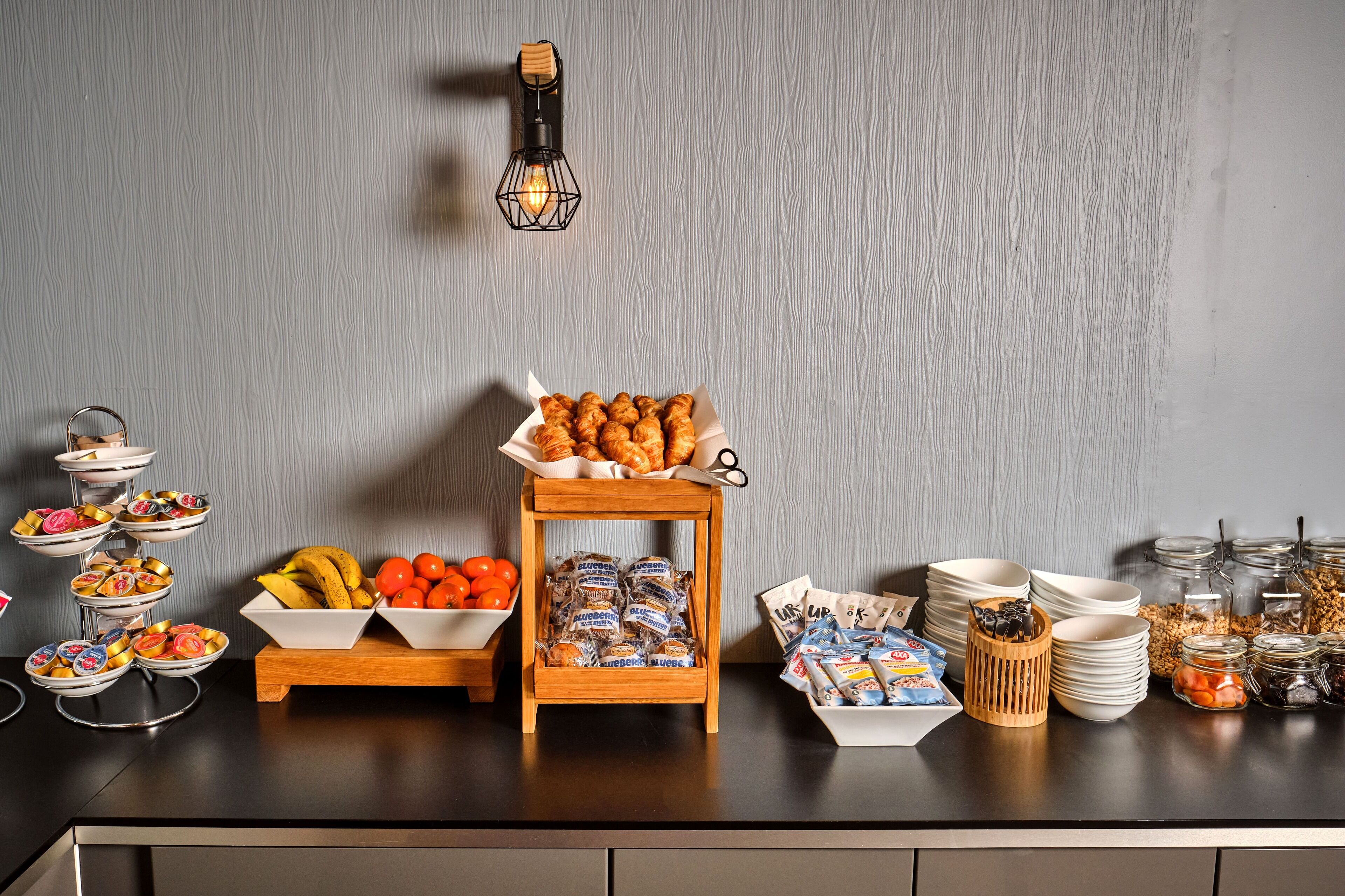 A buffet setup with various food items and condiments on a counter.