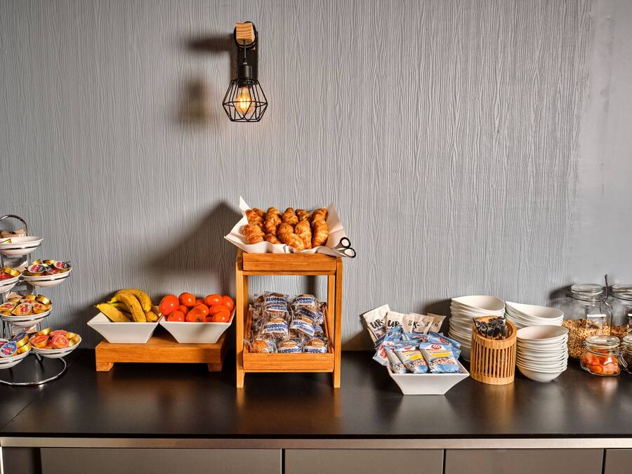 A buffet setup with various food items and condiments on a counter.