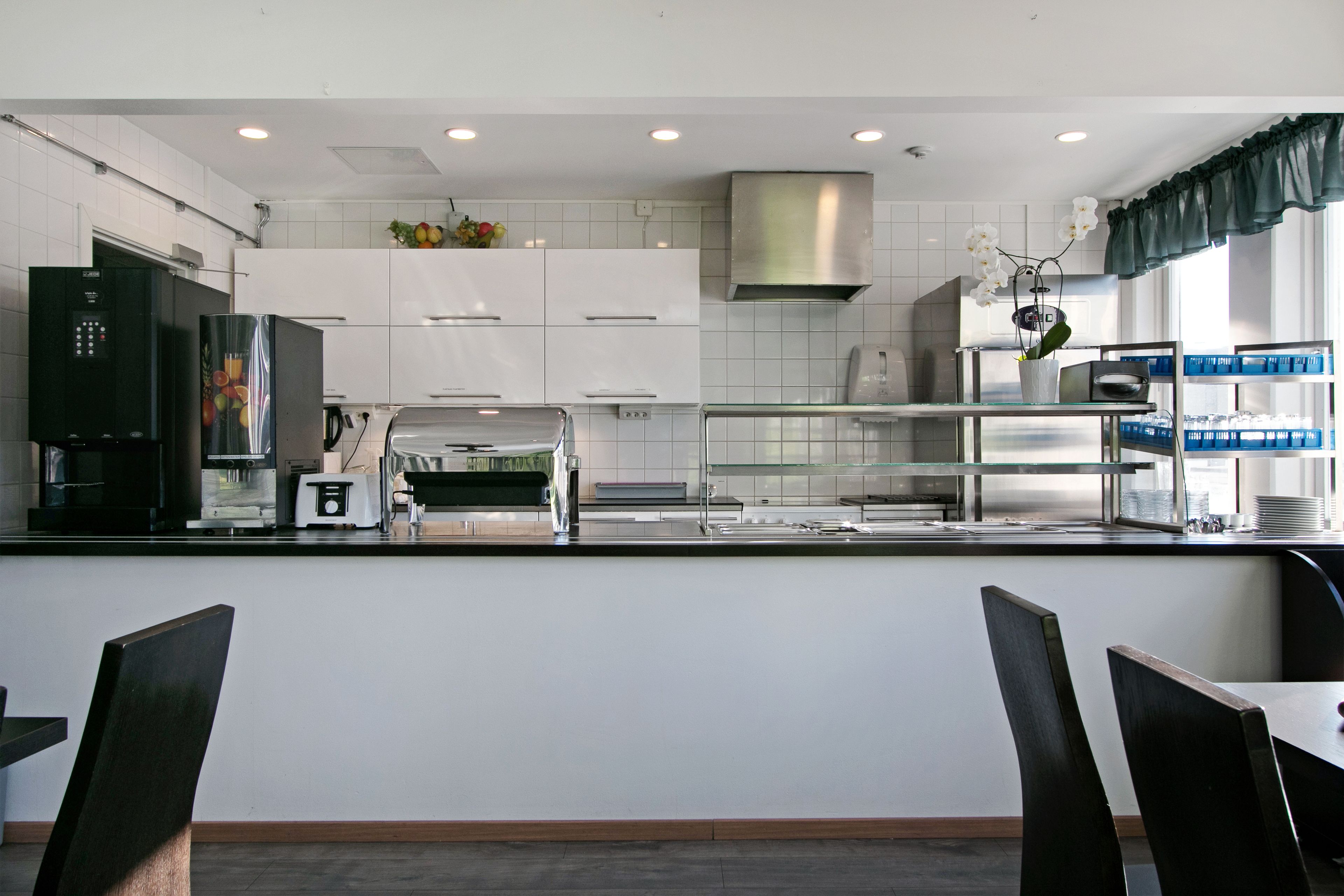 A modern kitchen with white cabinets, stainless steel appliances, and a glass backsplash.
