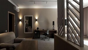 A modern bedroom with a sofa, a desk, a chair, a coffee maker, and a lamp. - Flowers Hotel (Chisinau)