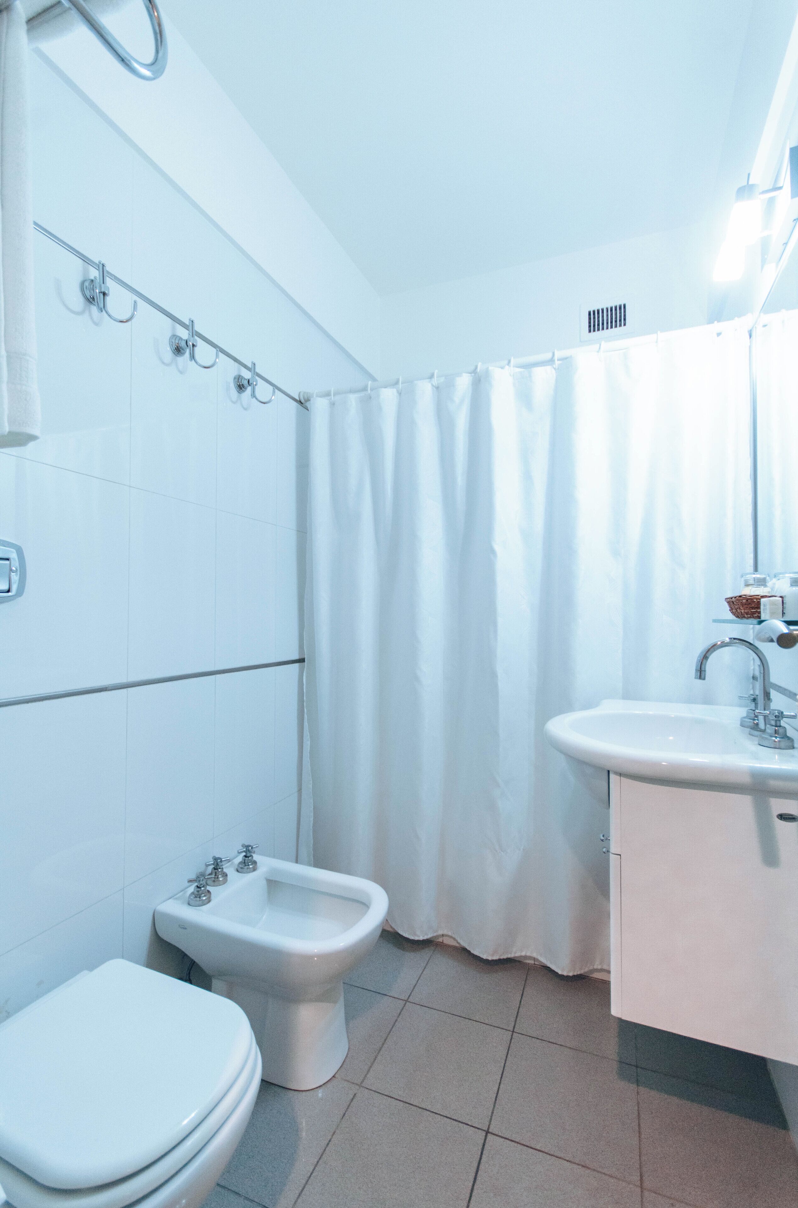 Une salle de bain équipée de toilettes, d’un bidet et d’un lavabo.