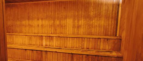 A sauna with wooden benches and a stone heating element.