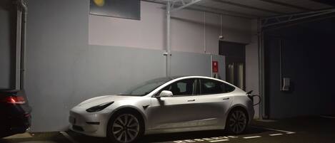 A parking garage with a white car parked in a designated space.