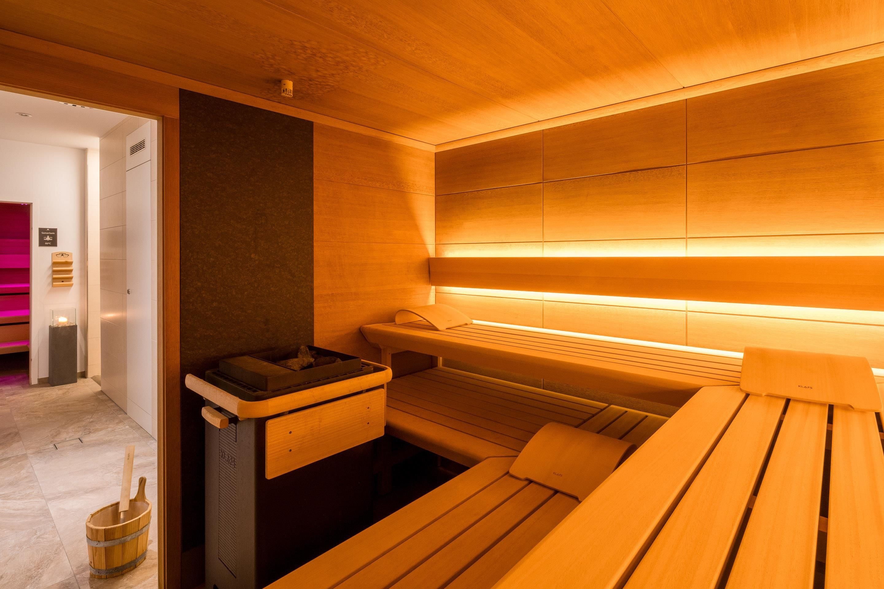 Un sauna con bancos de madera y un banco con toalla.