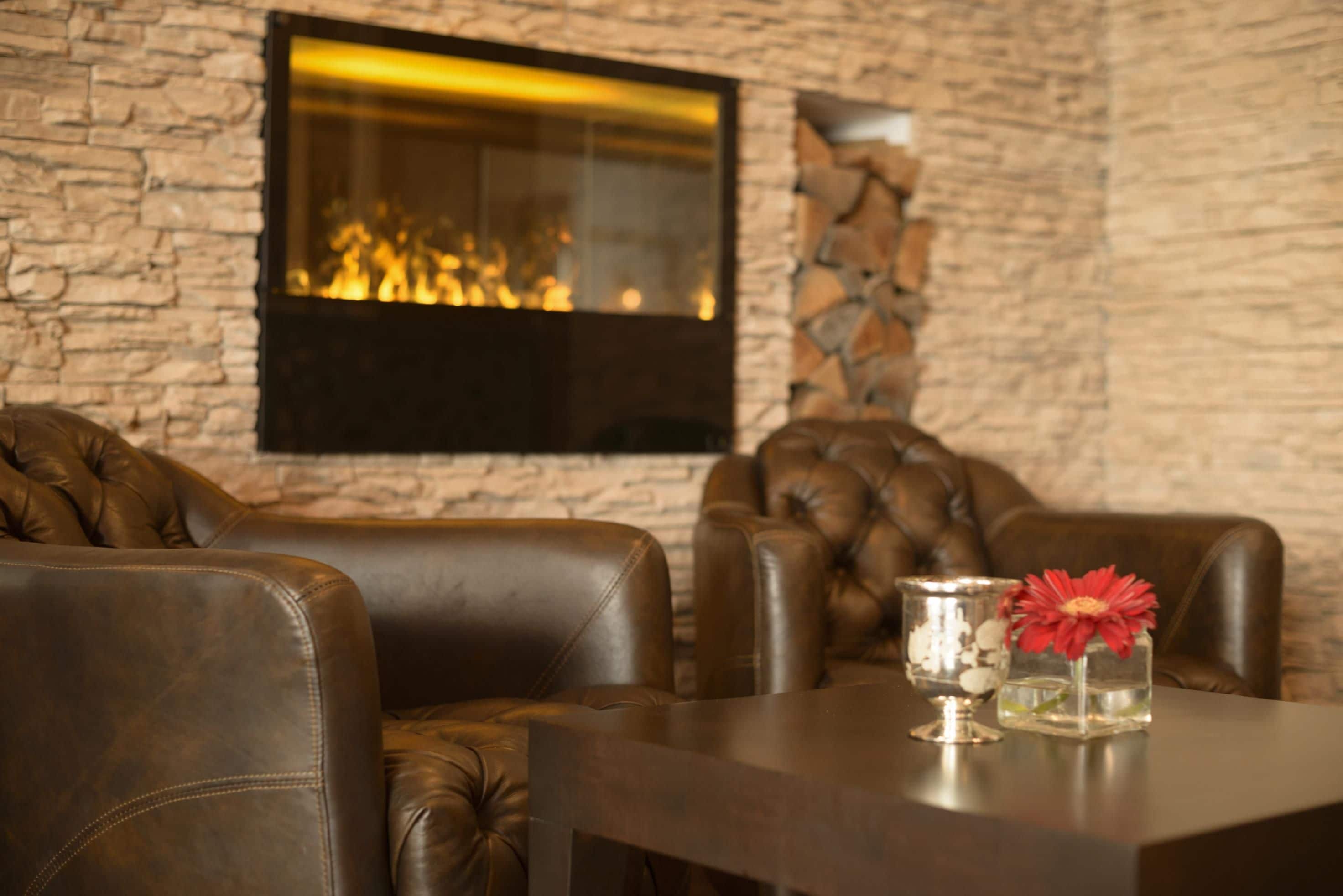 A cozy seating area with leather sofas and a fireplace.