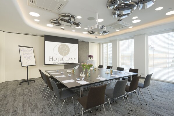 A conference room with a large table, chairs, and a projector screen displaying 'Hotel Lamm'. - Best Western Hotel Lamm (Singen)