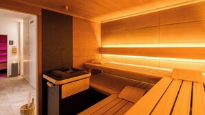 A sauna with wooden benches and a steam generator.
