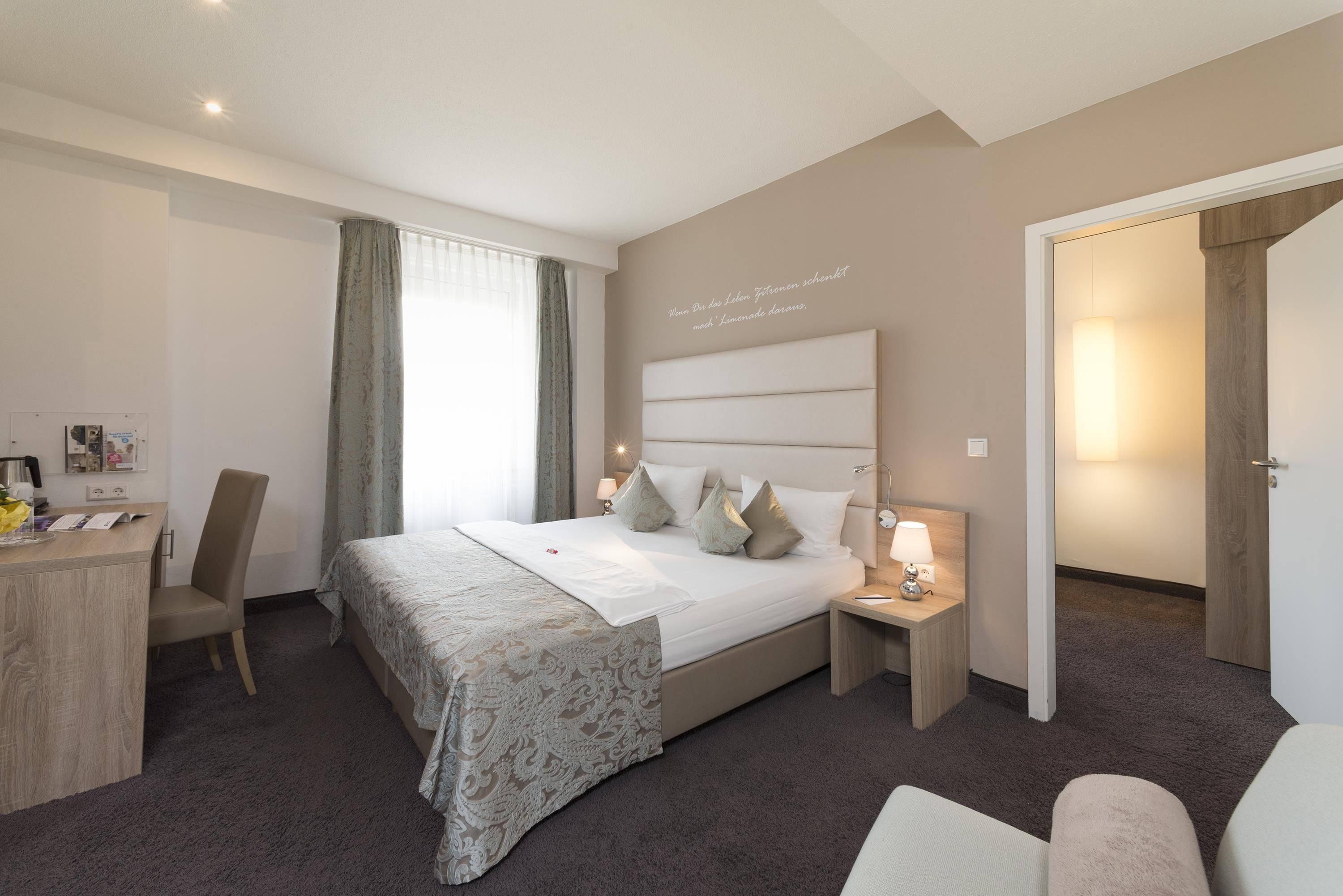 Une chambre d’hôtel avec un grand lit, un bureau et une chaise.