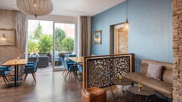 Interior moderno com área de jantar, assentos e vista através de uma porta de vidro.