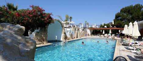 Una piscina al aire libre, sillones reclinables de piscina